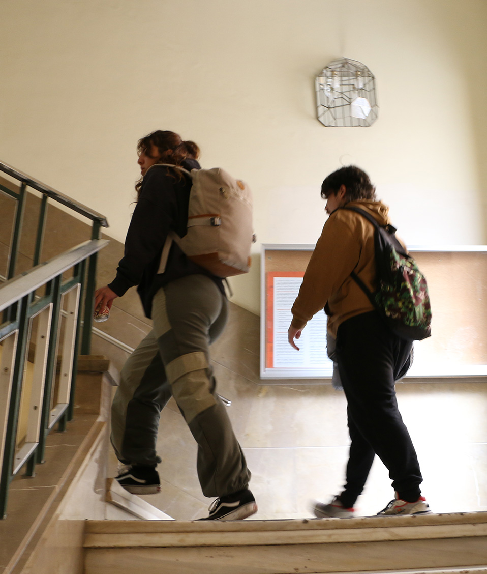 Un alumno y una alumna suben por las escaleras de la Facultad de Ciencias Políticas y Sociología.